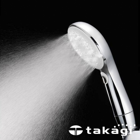 金屬質感的 takagi 手持式蓮蓬頭，黑色背景襯托出噴灑中細緻均勻的扇形水霧，手把側邊設有切換按鍵，整體外觀現代簡約。