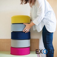 一疊五個 YUKA PUNI 墊高圓座墊，由上至下顏色分別為：芥末黃、淺灰藍、海軍藍、淺灰、亮粉紅。座墊為布質，圓柱形，堆疊擺放。