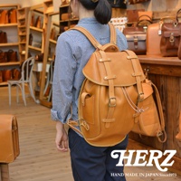 職人手作皮革經典雙扣後背包 R-152，採用棕褐色皮革製成，設計有雙扣翻蓋、側邊口袋及可調式肩帶，風格復古實用。