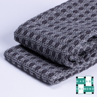 深灰色網格紋理的備長炭沐浴巾，材質柔軟，織法細緻，兩條沐浴巾堆疊擺放。