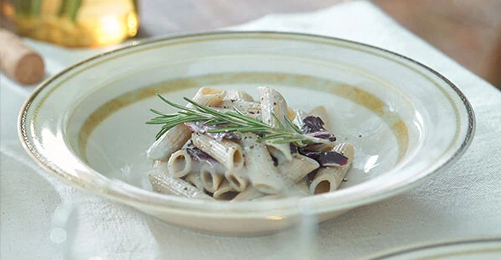 Anyware 美濃燒葉紋復古溫潤主食盤，盤身為米白色，邊緣有金色葉紋裝飾，盤中盛有奶油培根義大利麵，並以迷迭香點綴。