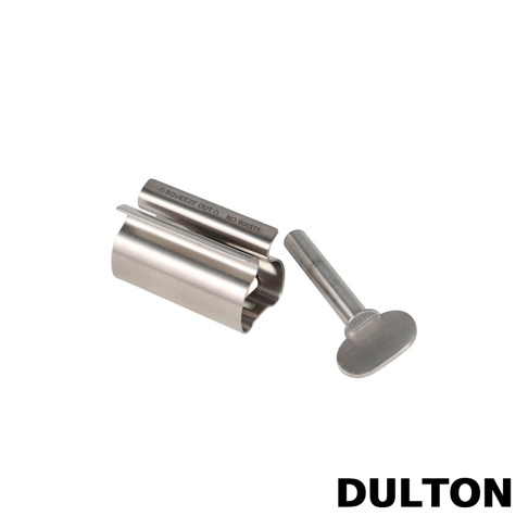 一個銀色金屬製的DULTON牙膏擠壓器，由一個管狀夾層和一個帶有旋轉把手的長條軸心組成，產品上刻有 SQUEEZE OUT NO WASTE 的英文字樣，呈現出簡約的工業設計風格。