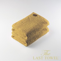 The LAST TOWEL 魔法瞬吸純棉柔浴巾，一組兩條，呈現溫暖的芥末黃色。浴巾為純棉材質，表面織有細緻的絨毛，觸感柔軟。頂部角落有一個小巧的咖啡色品牌標籤。