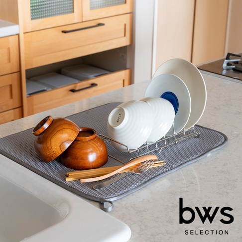 bws SELECTION 品牌的不鏽鋼可伸縮簡約瀝水架，上方擺放著木碗、碗盤和木筷，整體呈現在廚房檯面上。