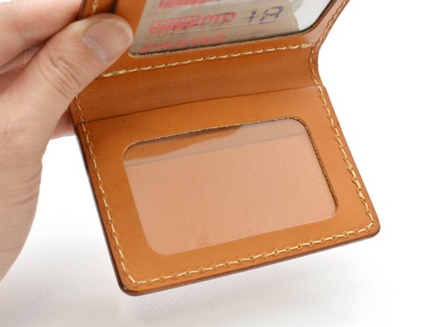職人手作皮革雙折票券收納夾 (KC-32)，淺棕色牛皮材質，雙折設計，設有透明視窗，縫線整齊。