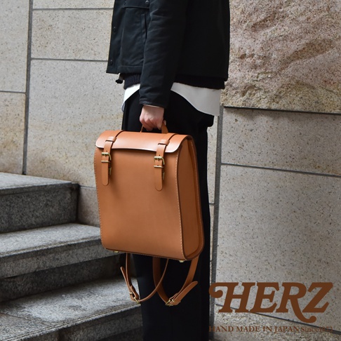 職人手作皮革後背包 R-31 (厚實版) 採用厚實的棕色皮革製成，款式簡約，擁有雙扣環開合設計，展現獨特復古風格。