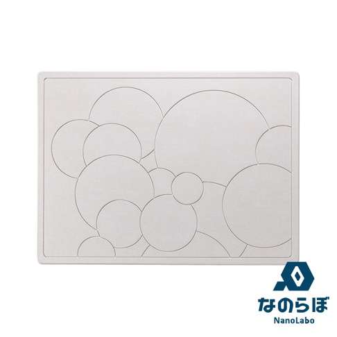 淺灰色珪藻土地墊，表面刻有大小不一的圓形圖案，錯落堆疊，下方有日文 Logo。