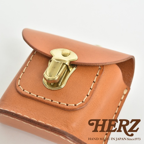 職人手作皮革耳機收納包，採用棕色皮革製成，配有黃銅色金屬釦環，車縫線明顯，設計簡約。