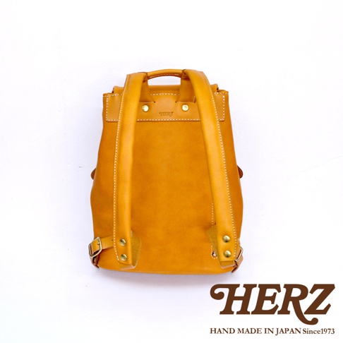 職人手作皮革多口袋後背包 R-135，芥末黃色，採用真皮材質，可見雙肩帶、頂部提把、金屬扣環及縫線細節，簡約設計。