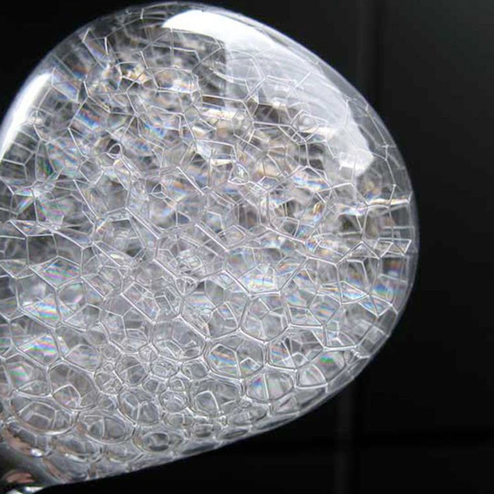 awaglass 泡時計/沙漏，透明玻璃球體內充滿細密的白色泡沫，泡沫結構呈現蜂窩狀的六邊形網格，光線穿透時產生虹彩效果。