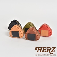 五個職人手作皮革小物收納包，造型為三角飯糰，顏色包含黑色、軍綠色、淺棕色、深棕色及橘紅色，每個收納包皆有拉鍊開合，並有一個方形的黑色皮革裝飾片，以白色縫線縫製在收納包正面。