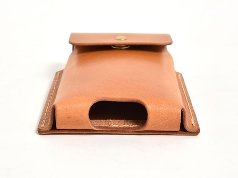 淺棕色皮革製成的手機收納包，正面有黃銅按扣，側面和底部有縫線細節，底部有手機開口。