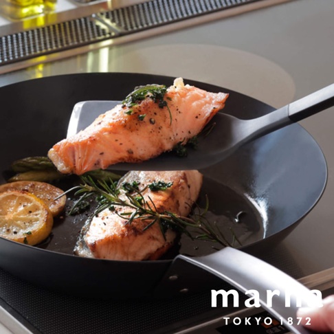 marna Tokyo 1872 標誌，下方有兩個煎好的鮭魚排，其中一個正在被矽膠鍋鏟盛起，周圍擺放著檸檬片和迷迭香