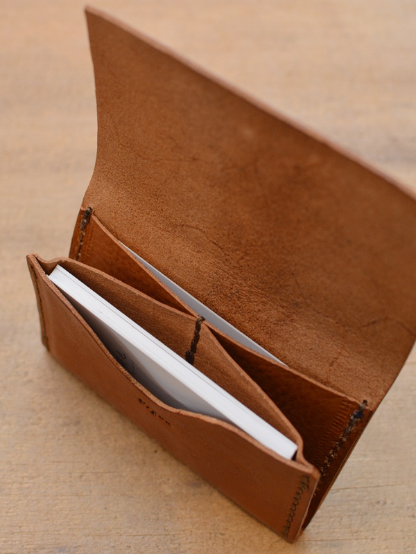 職人手作咖啡色皮革薄型名片夾，內有三個夾層，可收納多張名片。皮革質地自然，邊緣車縫線清晰。