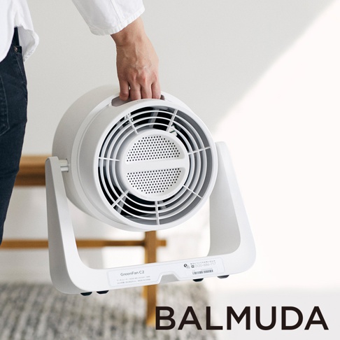 手持白色圓形循環扇，扇葉為黑色網狀，配有白色支架，整體簡約現代。