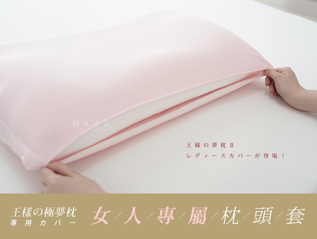 粉紅色「王樣の極夢枕」專屬枕套，材質柔軟，由雙手正在套入枕頭，露出白色枕芯。