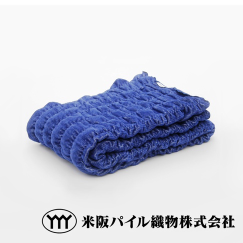 藍色波浪細絨質感的四季毯，柔軟且具有紋理，疊放在白色背景上。