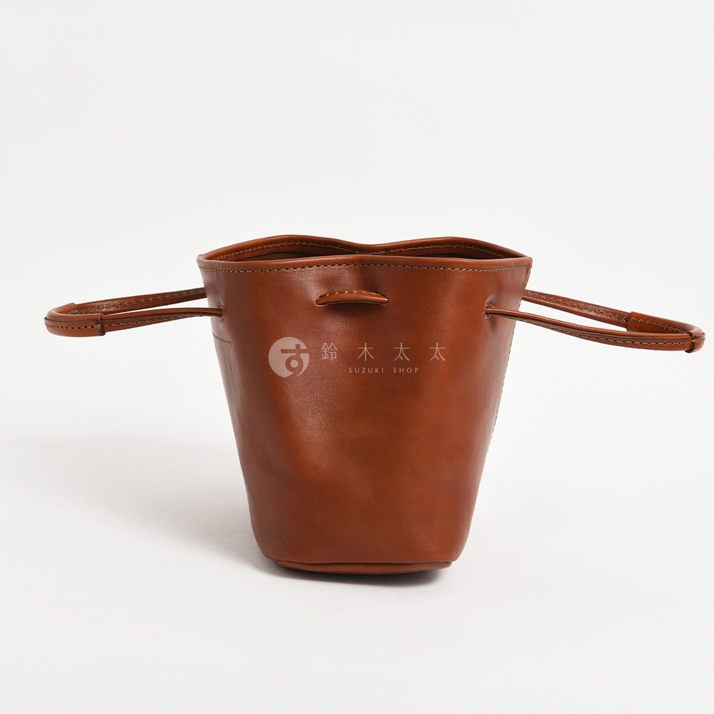 鈴木 SUZUKI SHOP 標誌的棕色皮革水桶包，兩側有手柄