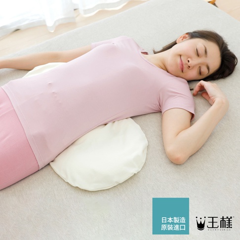 一名女子側臥，腰部下方墊著一個米白色、半月形、柔軟的腰枕。