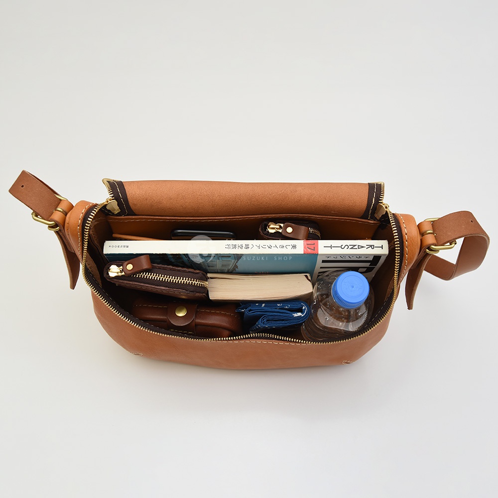 HERZ 馬鞍包內裝有書本、手機、錢包、小零錢包和一瓶水