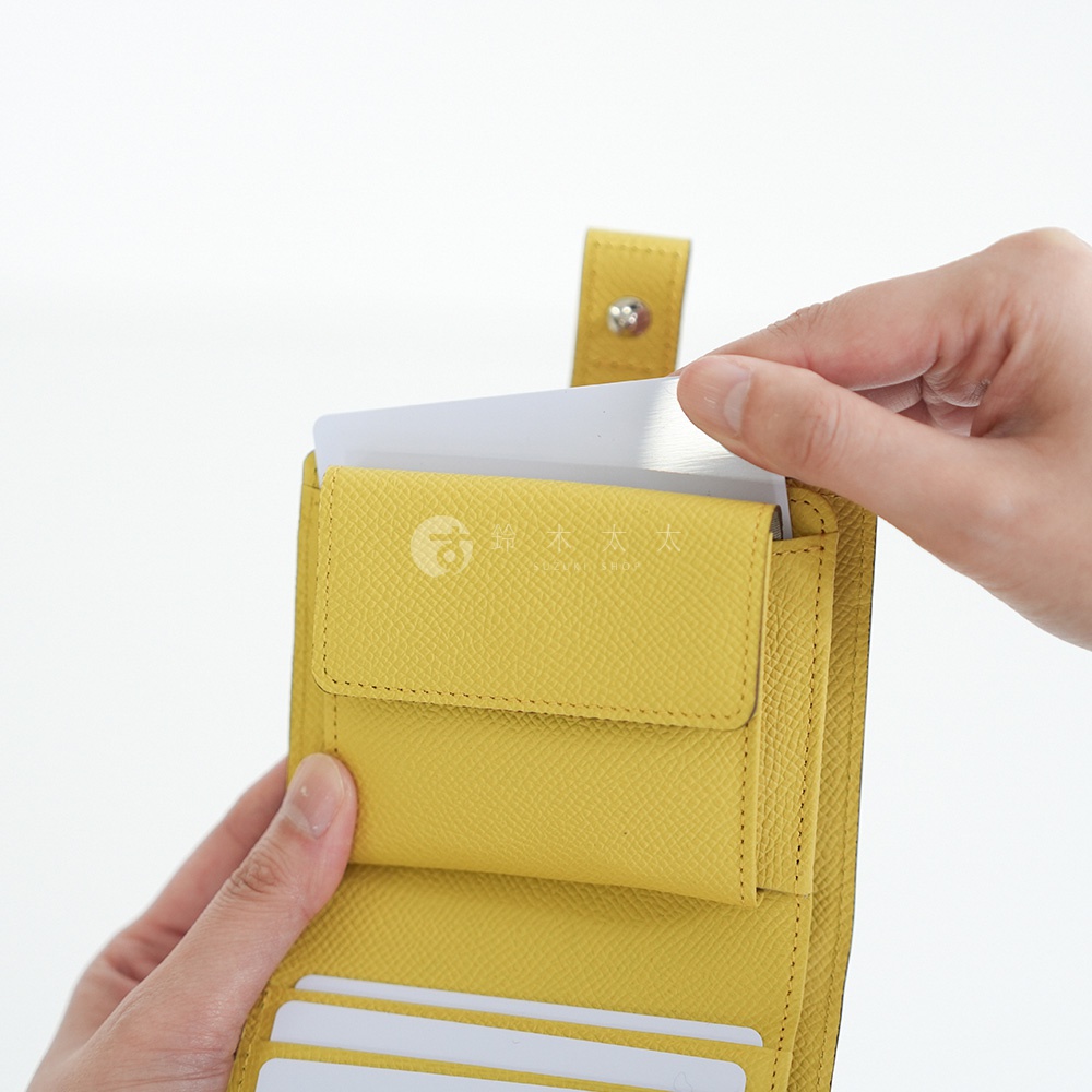 黃色皮革短夾，手正在從卡夾中取出白色卡片