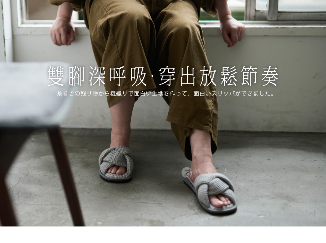 室內拖鞋採用交叉編織的鬆餅紋設計，灰色鞋面與大地色系的褲裝搭配，營造出舒適居家氛圍。