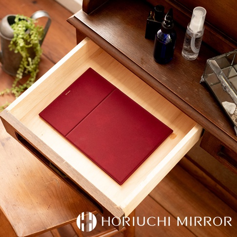 NAPURE 桌上型2Way折疊化妝鏡，酒紅色，光滑材質，置於木製抽屜內。