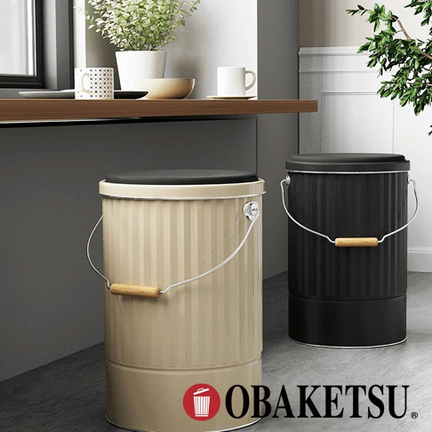 OBAKETSU 品牌標誌與兩款手工製凳子儲物桶，分別為米色和黑色，皆設有木質提把。