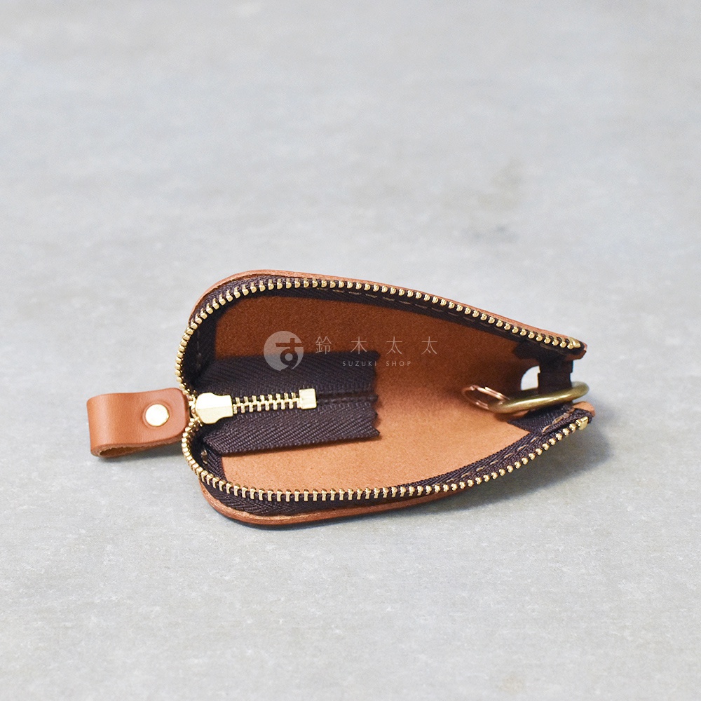 職人手作皮革Organ拉鍊鑰匙包，淺棕色皮革，拉鍊為深棕色，搭配金色拉鍊頭和鑰匙環，側邊有皮革製的按扣綁帶。