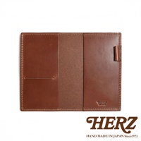 職人手作皮革輕便記事本書套，採用鞣製皮革製成，顏色為經典棕色。書套設計簡潔，內部有兩個主要隔層，左側隔層設有票卡夾層。右側隔層外側有一個皮革筆套，方便攜帶筆。整體縫線工整，展現職人細膩的工藝。