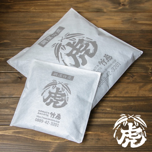 兩個白色無紡布包裝袋，上面印有灰色調濕竹炭字樣與虎形圖案，以及網址和電話。