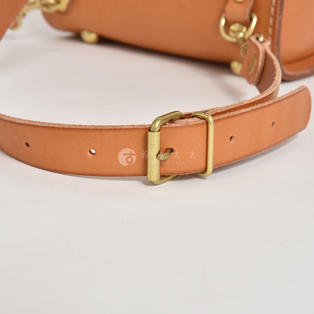 職人手作皮革經典學院風迷你後背包 R-24，此圖為淺棕色皮革製作的背包肩帶，配有黃銅色金屬調整扣。