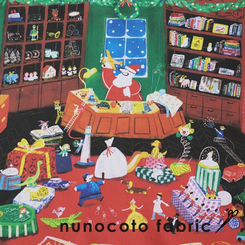 聖誕老人坐在堆滿玩具的桌子旁，手中拿著一架飛機，周圍散落著各式聖誕禮物、玩具兵、玩偶、聖誕樹和書架，背景為綠色牆壁及有雪花圖案的窗戶，整體呈現溫馨歡樂的聖誕場景。