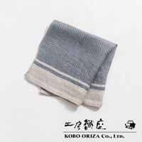 一條藍灰色純亞麻斜紋萬用廚房拭巾，帶有米色和藍色滾邊，折疊於白色背景上。