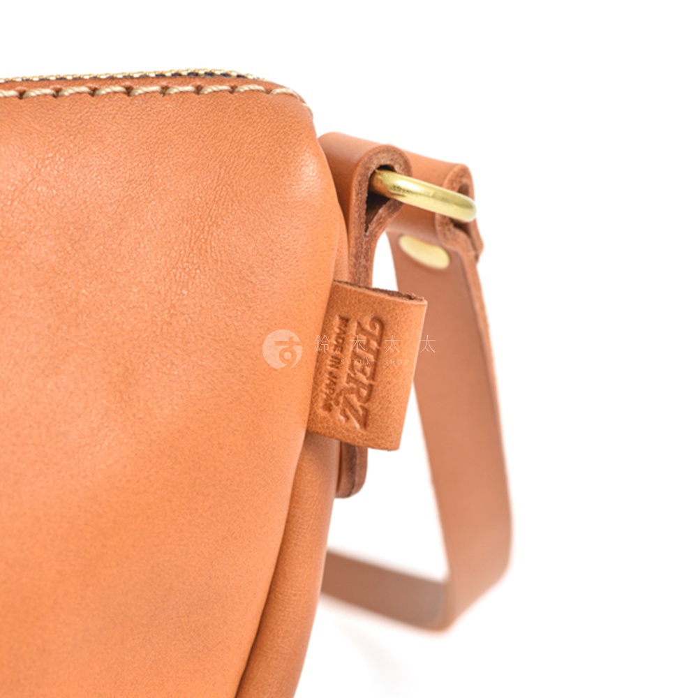 日本 HERZ 皮革半圓馬鞍包的近拍，展現皮革的細緻紋理與品牌標誌