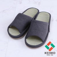 一雙深灰色藺草室內拖鞋，鞋面為布料材質，內裡及鞋墊為藺草編織，鞋頭鏤空設計。