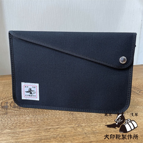 犬印純綿帆布平板收納包（大），黑色，帶有銀色按扣和一個印有「東京 淺草 犬印製作所」的白色標籤。