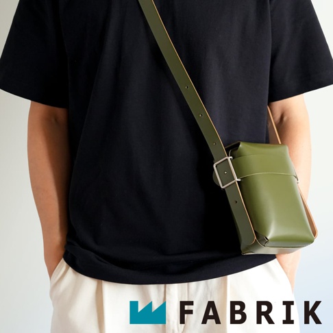 FABRIK 品牌綠色皮革迷你斜背包，搭配黑色上衣和米白色褲子，展現簡約時尚風格