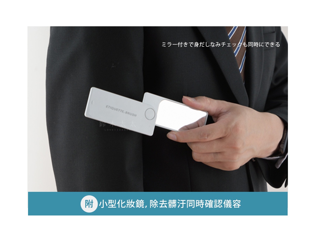 白色長方形隨身衣物除塵刷，附有鏡面，握在穿著黑色西裝、繫著藍色條紋領帶的人手中，展示其便攜性和多功能性。