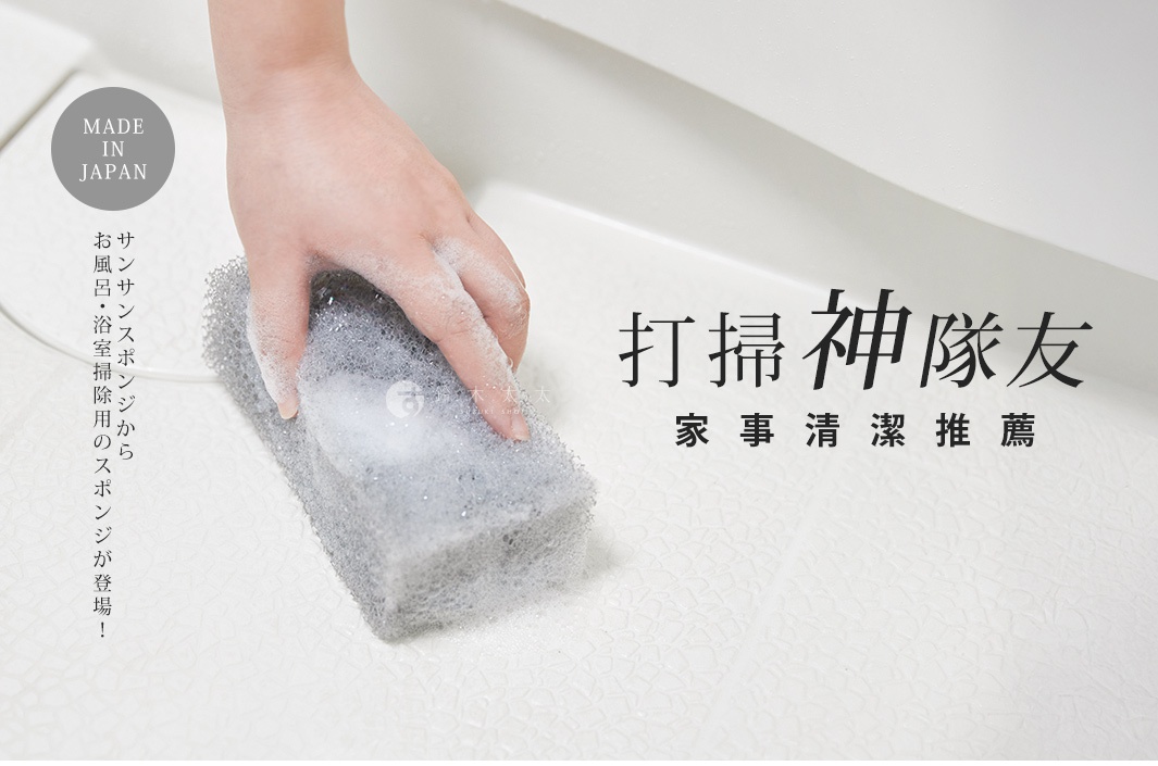 手持灰色、網狀質地的浴室清潔海綿，沾有泡沫，正在擦拭白色浴缸內壁。
