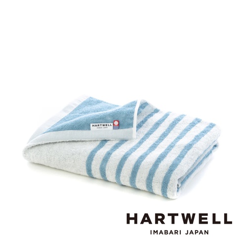 一條藍白條紋的薄浴巾，由棉質製成，觸感柔軟。浴巾一角標有「HARTWELL IMABARI JAPAN」的品牌標籤。