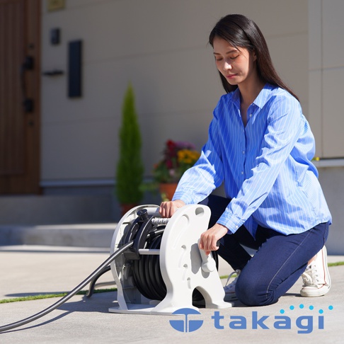 takagi 品牌商標與標誌，一名女性正蹲在地上，專注操作一個白色捲線器，上面纏繞著黑色的水管。