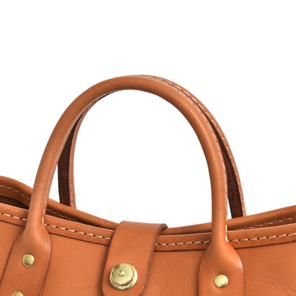 職人手作皮革迷你托特包，採用光滑棕色皮革材質，配有縫線處理的提把和金屬釦。