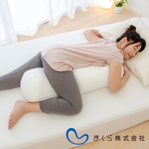 側臥女子使用白色圓柱形夾腿枕，枕頭置於雙腿之間，枕套為素色。