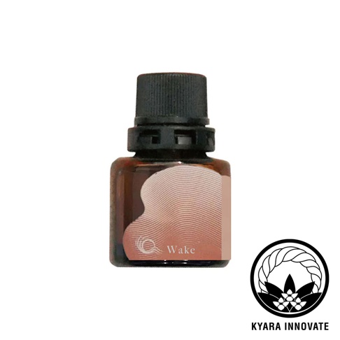 KYARA INNOVATE 品牌黑色瓶蓋的琥珀色精油小瓶，標籤上有粉紅色曲線圖案和 Wake 字樣，右側有品牌標誌