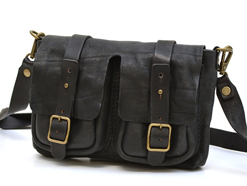 黑色皮革製成的前雙口袋肩背包，帶有兩個皮帶扣和可調節肩帶，搭配復古黃銅色五金配件。
