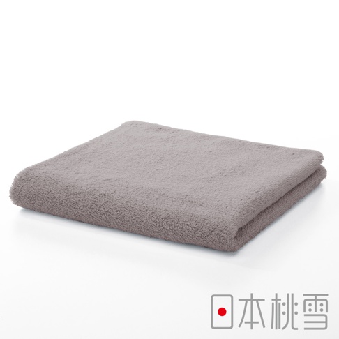 一條淺灰色的精梳棉飯店毛巾，材質柔軟，表面有細緻的絨毛，呈現折疊狀態。