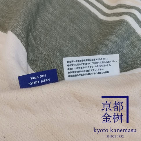 AORA 六層紗文青風條紋單人毯，織有綠色與白色條紋，質地輕柔，附有「Since 2015 KYOTO JAPAN」標籤及日文洗滌說明。