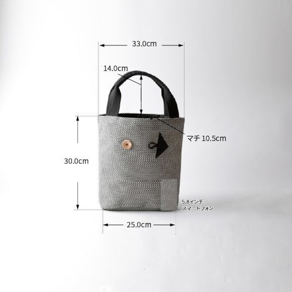 灰色三河木綿刺子織直式收納托特包，有黑色提把，正面有一個圓形木質鈕扣和黑色箭頭圖案，包體尺寸約為寬25公分、高30公分，提把高度約14公分，厚度約10.5公分。