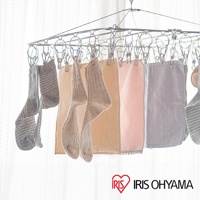 不鏽鋼曬衣架上掛著多雙灰白色條紋及素色襪子，以及淺黃、粉紅色、淺灰色的毛巾。